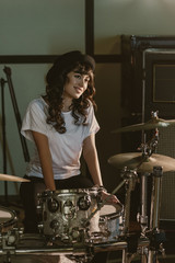 attractive female drummer sitting at drum set
