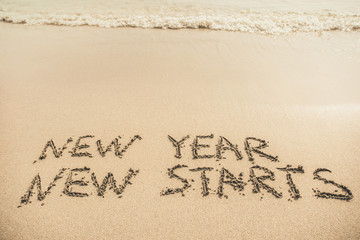 New Year New Starts text written on the sand