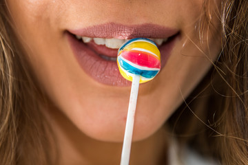 Mund einer jungen Frau mit Lolli an Lippen