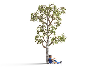 Little footballer leaning against a birch tree