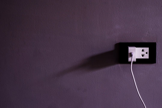 Electronic house plug on gray wall 