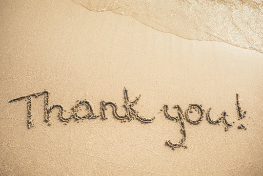 Thank you text written on the sand