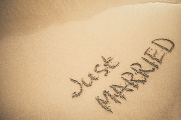 Just Married text written on the sand