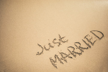Just Married text written on the sand