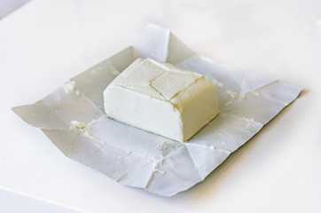 Close-up of a sack of open, cream cheese, on a white background. Shallow depth of focus.