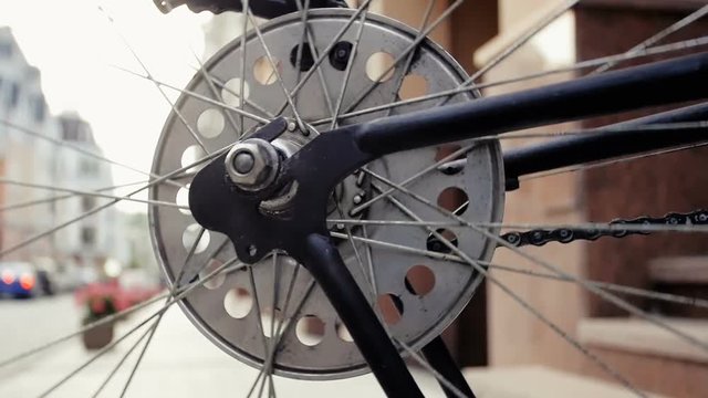 Closeup slow motion footage of rotating bicycle wheel on street