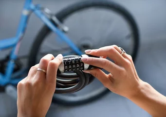 Foto auf Acrylglas Fahrräder Combination bike lock in female hands