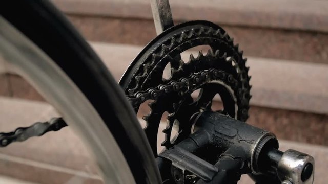 Closeup slow motion footage of rotating pedals, chain and wheel of old bicycle