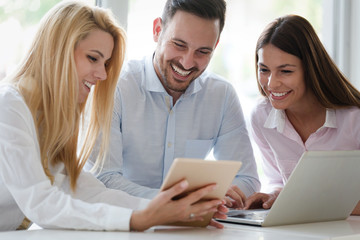Workteam in office working together on laptop