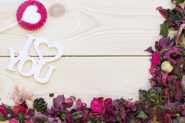Wooden background with a corner of petals and leaves