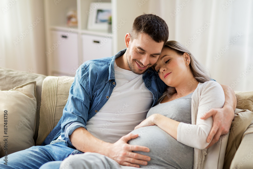 Wall mural man hugging pregnant woman at home