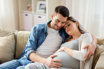 man hugging pregnant woman at home - Powered by Adobe