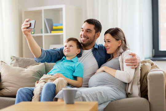 happy family taking selfie with smartphone at home