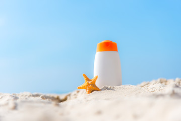 Protective sunscreen or sunblock and sunbath lotion in white plastic bottles on tropical beach, summer accessories in holiday, copy space.  Summer Concept