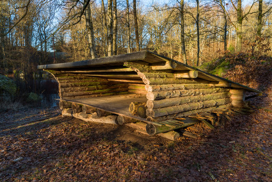 Roofed timbered wind shelter for sleepover in the wilderness.