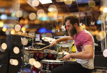 Fototapeta na wymiar male musician playing cymbals at music store