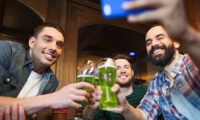 friends taking selfie with green beer at pub