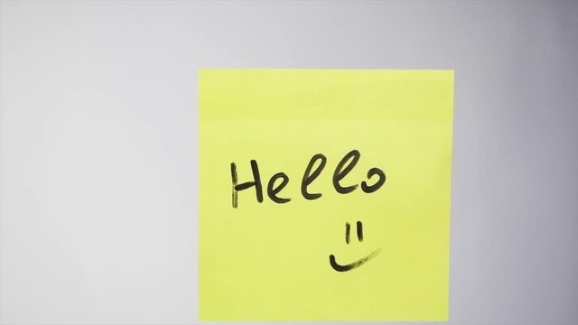 Sticker with the words "Hello" on the glass. Hello - the inscription on the paper memo, business concept