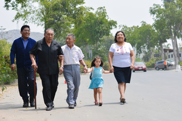 Latin family of three generations walking on the street.