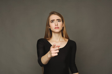 Obraz premium Sad girl pointing finger at camera