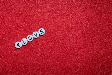 Love letter on a red background, letters in the form of plastic buttons with a sign hashtag