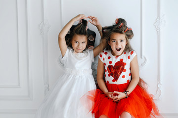 Fashionable girls wth curlers in luxurious lush dresses