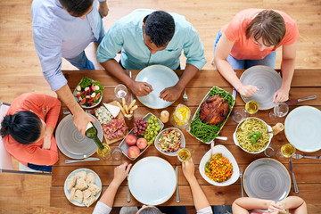 group of people eating at table with food