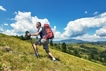 Fototapeta premium Hiking in the mountains in the summer with a backpack.