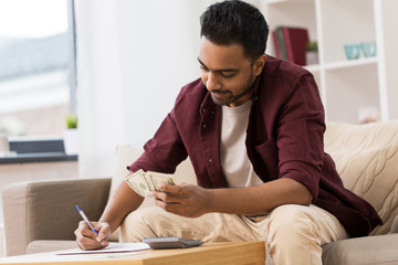 man with money and calculator filling papers