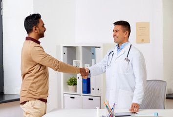 doctor and male patient shaking hands at hospital