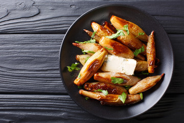 Crispy caramelized onions shallot with blue cheese and parsley closeup on a plate. horizontal top view