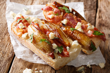 Open sandwiches with caramelized balsamic shallots, bacon and roquefort cheese close-up. horizontal