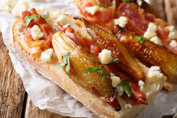 Sandwiches with caramelized shallots, bacon and roquefort cheese macro. horizontal