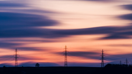 Fototapeta na wymiar Des pylones électriques au coucher de soleil
