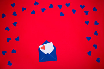 Blue envelope with love letter above red background with many blue hearts around. Love concept
