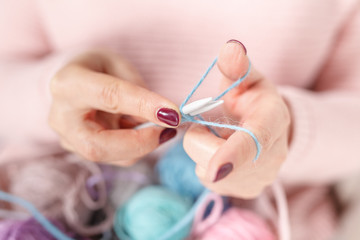 Knitting baby things, close up colored clew in hand