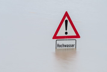 Schild Achtung Hochwasser, fast im Wasser versunken