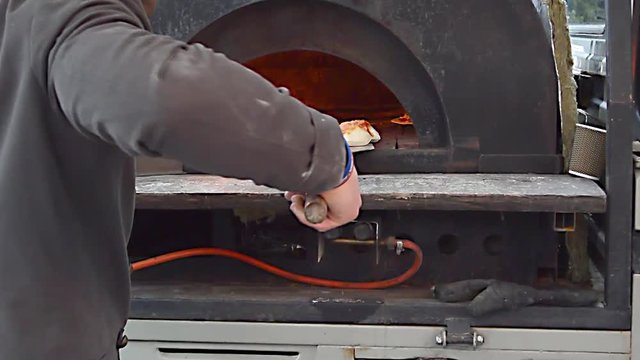 Baking of pizza in the furnace on a New Year's market