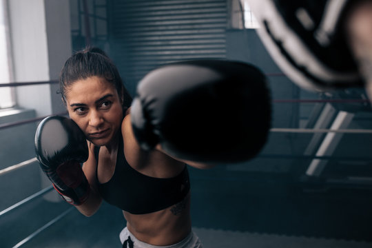 Female boxer training inside a boxing ring