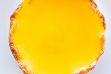 A big cheese tart fill with orange jam ready to eat on white plate on table