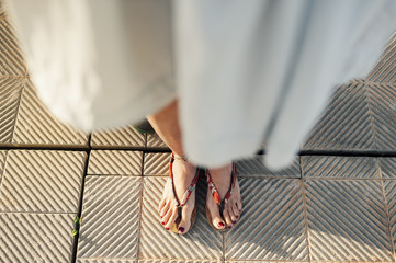 Close view of  woman feet wearing sandals in the street