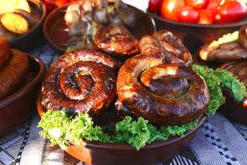 Round fried sausages in a bowl on a table with snacks