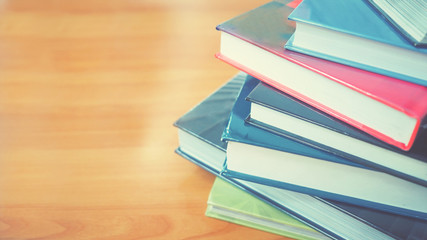 Book stack in the library room on wood desk and selective focus for business and education background, back to school concept