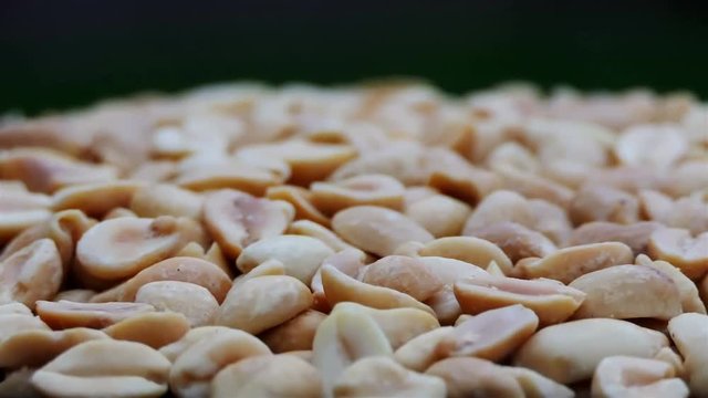 Close up of roasted and salted peanuts isolated on black. Rotation of peanuts nuts in slow motion. Food and drinks background 4K. dry fruits and nuts rotating in slow motion. food texture closeup.