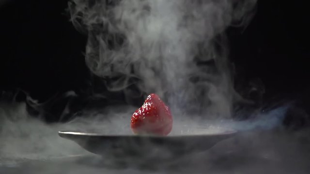 Liquid nitrogen pours on the strawberry.
