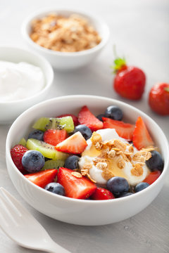 fruit berry salad with yogurt and granola for healthy breakfast