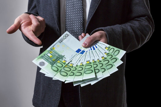 A Thousand Euros. A Man offering 100 euro banknotes.