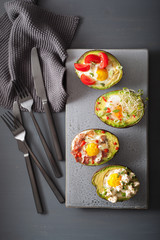 eggs baked in avocado with bacon, cheese, tomato and alfalfa sprouts