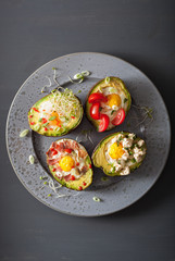 eggs baked in avocado with bacon, cheese, tomato and alfalfa sprouts