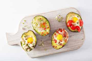 eggs baked in avocado with bacon, cheese, tomato and alfalfa sprouts